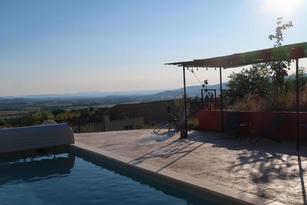 a swimming pool with a table and chairs next to it at tempepailla in Roynac