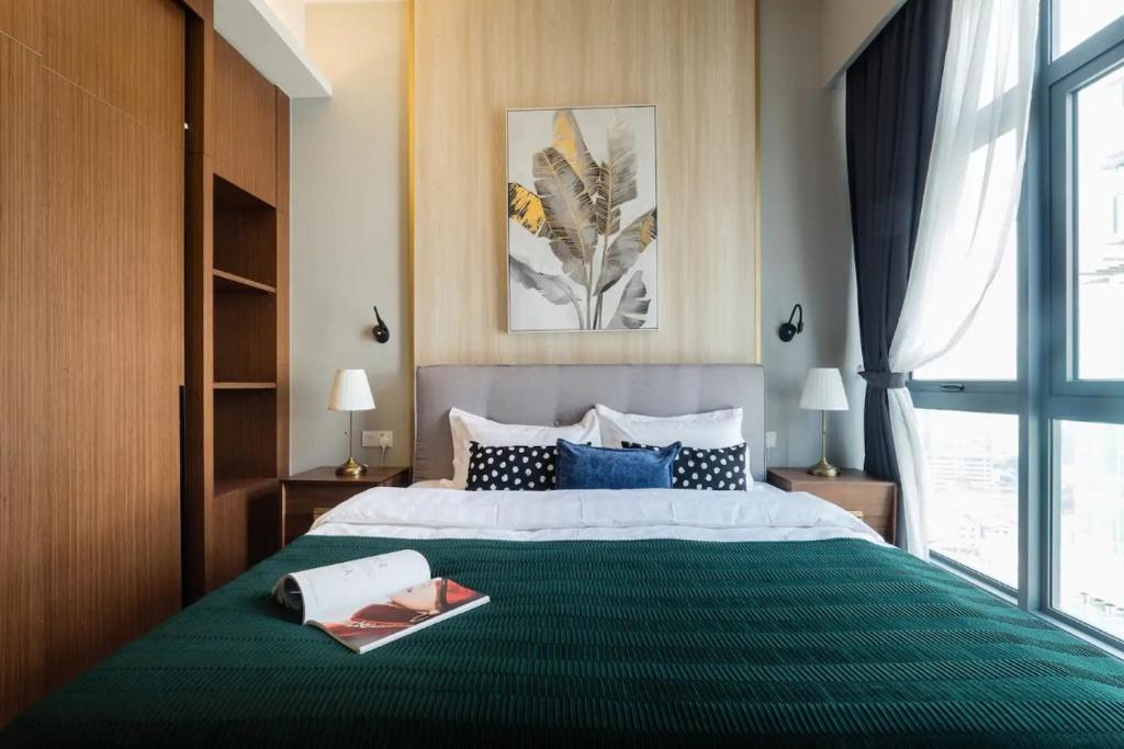 een slaapkamer met een groot bed en een groene deken bij TriBeCa 2bedroom 3min walk to bukit bintang 2 rooftop pool in Kuala Lumpur