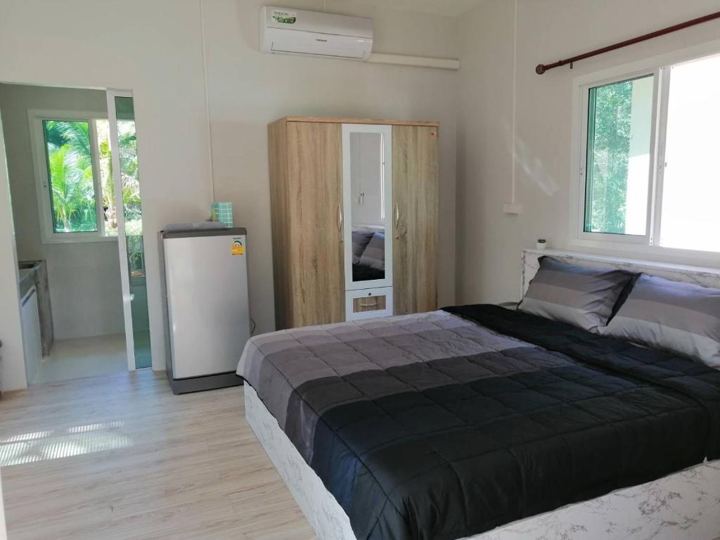 - une chambre avec un grand lit et un réfrigérateur dans l'établissement บ้านสวนคุณตา Baan Suan Khun ta, à Ko Chang