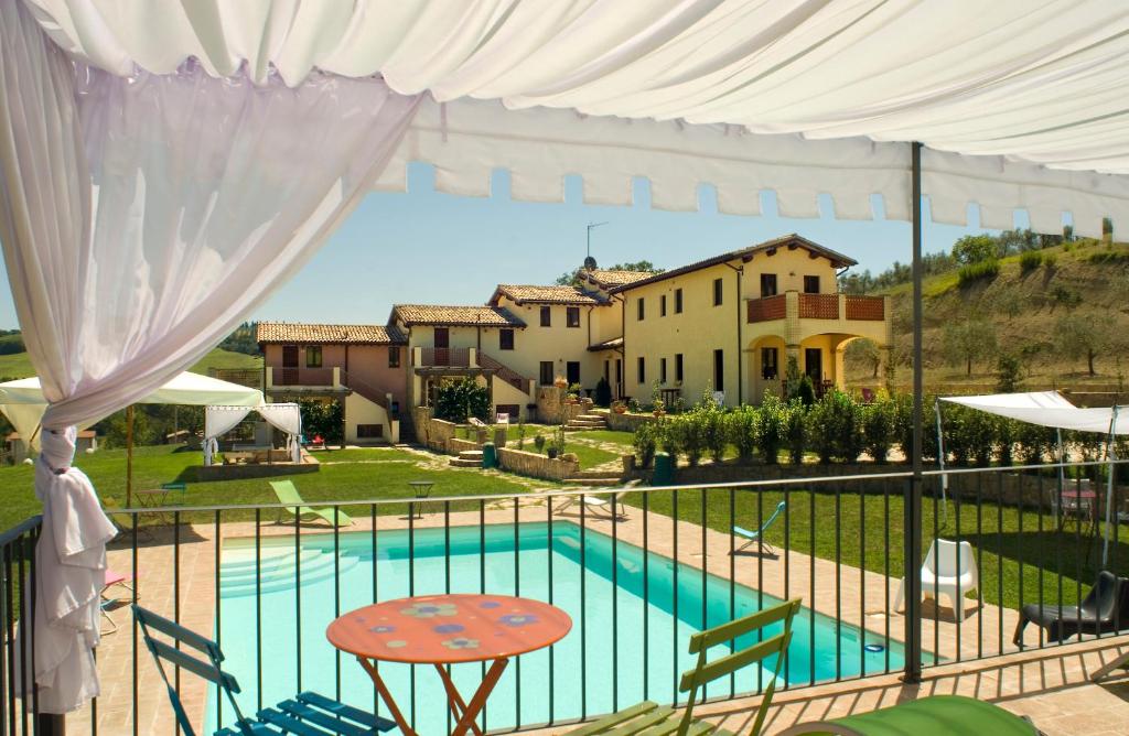 vistas a la piscina desde el balcón de una casa en Borgo Le Capannelle, en Castel Ritaldi