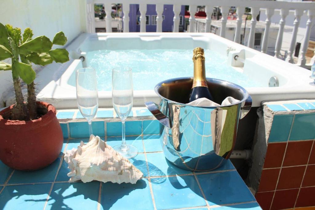 a bottle of champagne in a bucket next to a bath tub at Cancun Guest House 4 Terrace Tub in Cancún