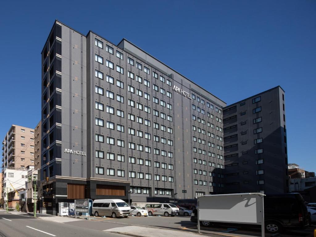 a large building with cars parked in front of it at APA Hotel Kyoto-Eki Higashi in Kyoto