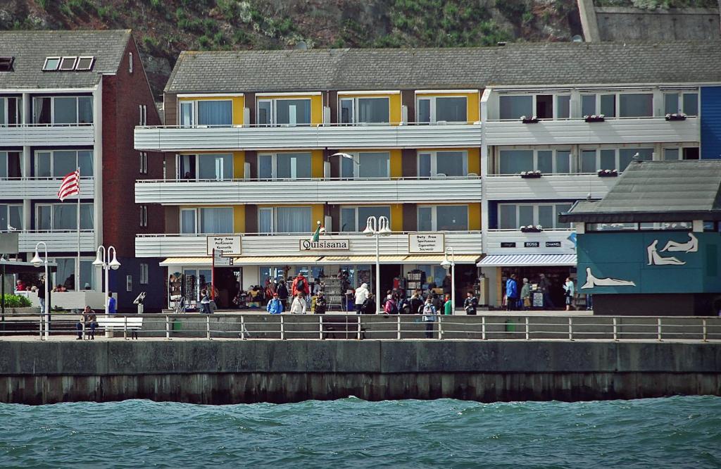 a building on a pier next to the water at Hotel Quisisana & Appartements Quisi in Helgoland