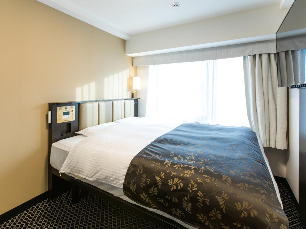 Postel nebo postele na pokoji v ubytování APA Hotel Kyoto Ekihigashi