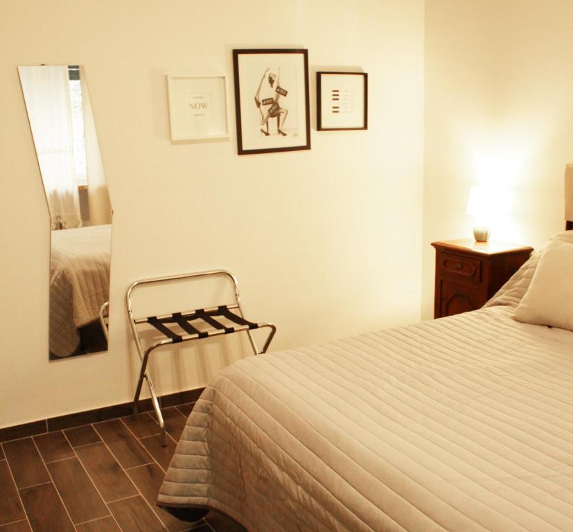 a bedroom with a bed and a chair and a mirror at La Casetta di Alvaro in Domegliara