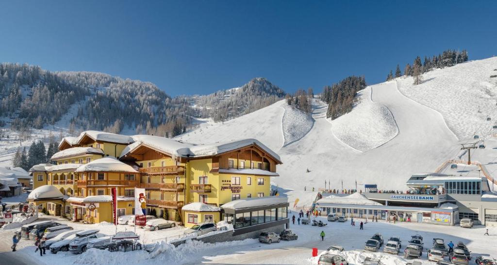 a ski lodge with snow on a mountain at Hotel Zauchenseehof in Zauchensee