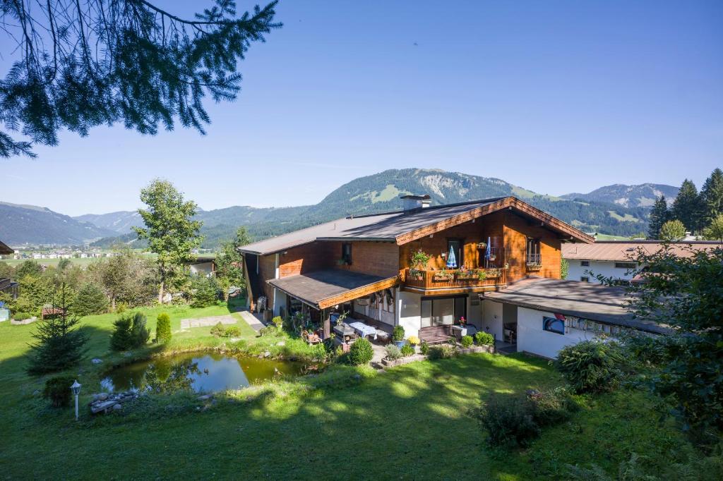 a house with a large yard with a pond at Haus Christl am Horn in Sankt Johann in Tirol