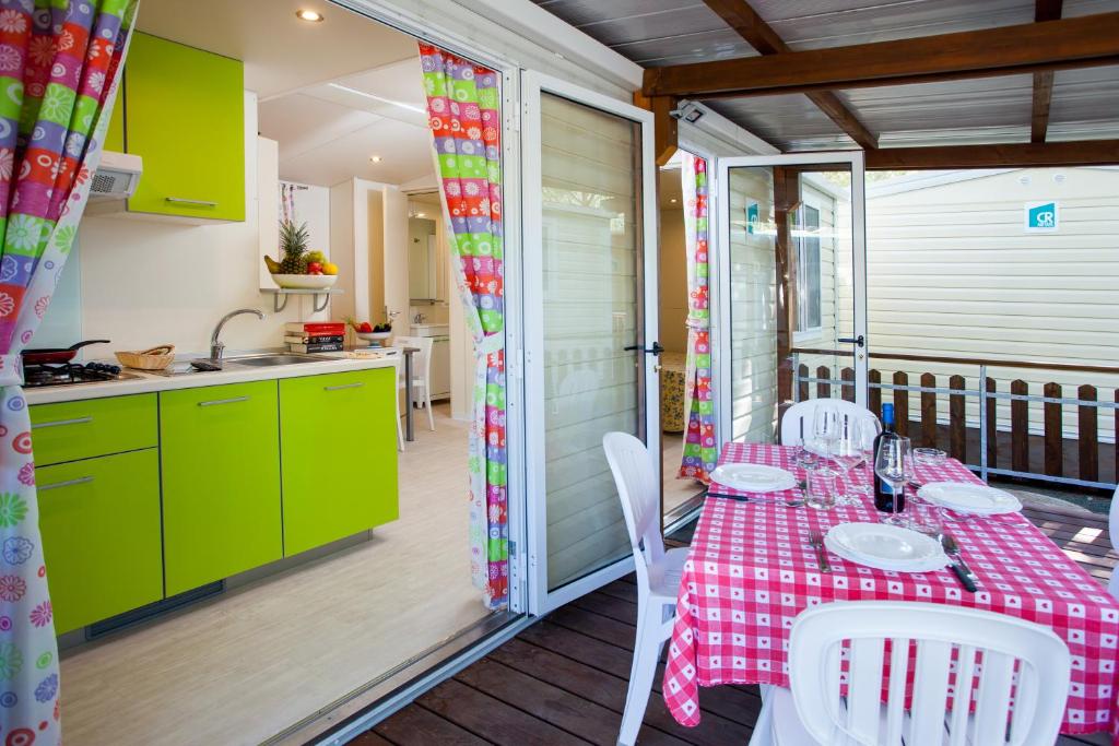 eine Küche und ein Esszimmer mit einem Tisch und Stühlen in der Unterkunft Camping Village Mareblu in Marina di Cecina