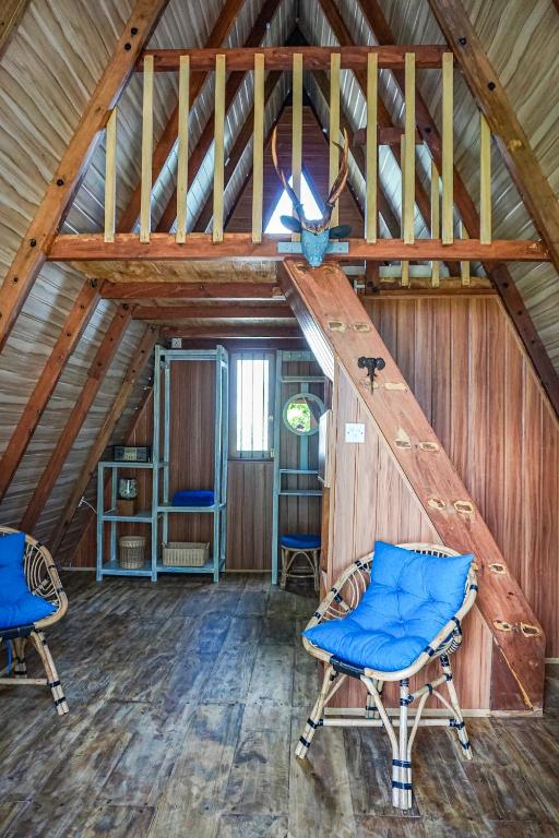 a attic room with two chairs and a ladder at Nuga Eden Tangalle in Tangalle