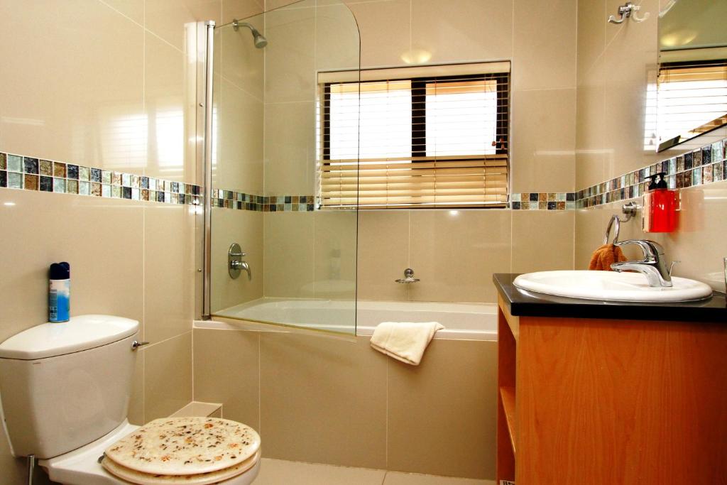 a bathroom with a shower and a toilet and a sink at Casa Mia Guesthouse in Table View