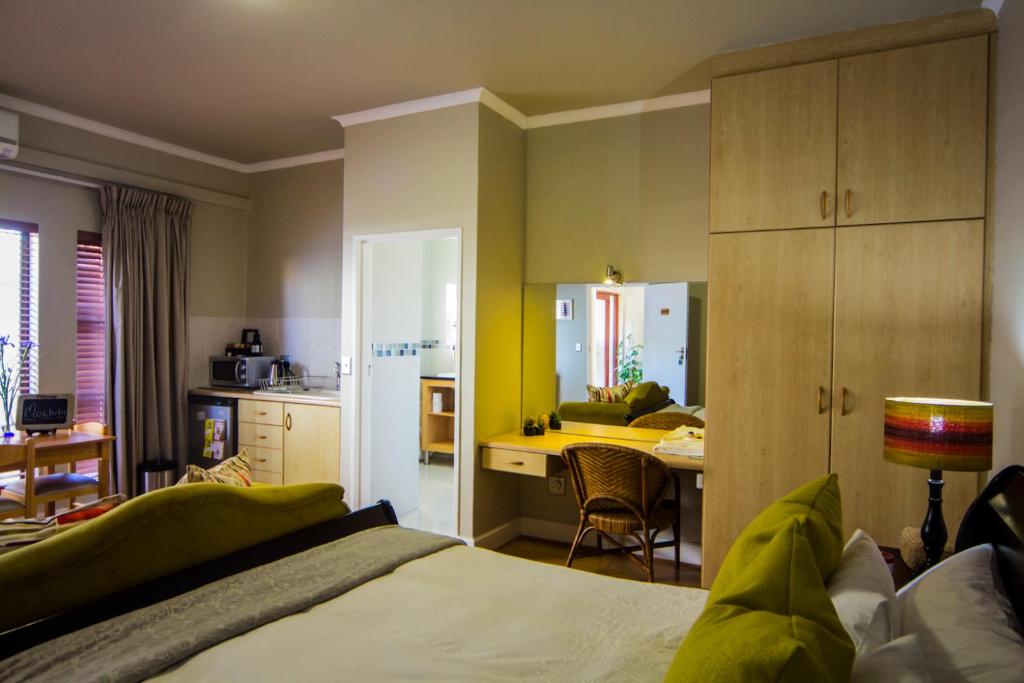 a bedroom with a bed and a kitchen with a table at Casa Mia Guesthouse in Table View