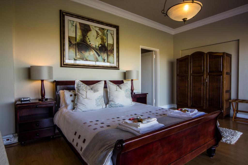 a bedroom with a large bed with two plates on it at Casa Mia Guesthouse in Table View