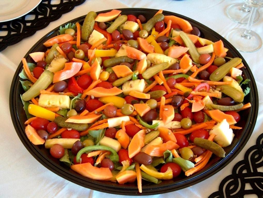a black plate of vegetables on a table at Casa Mia Guesthouse in Table View