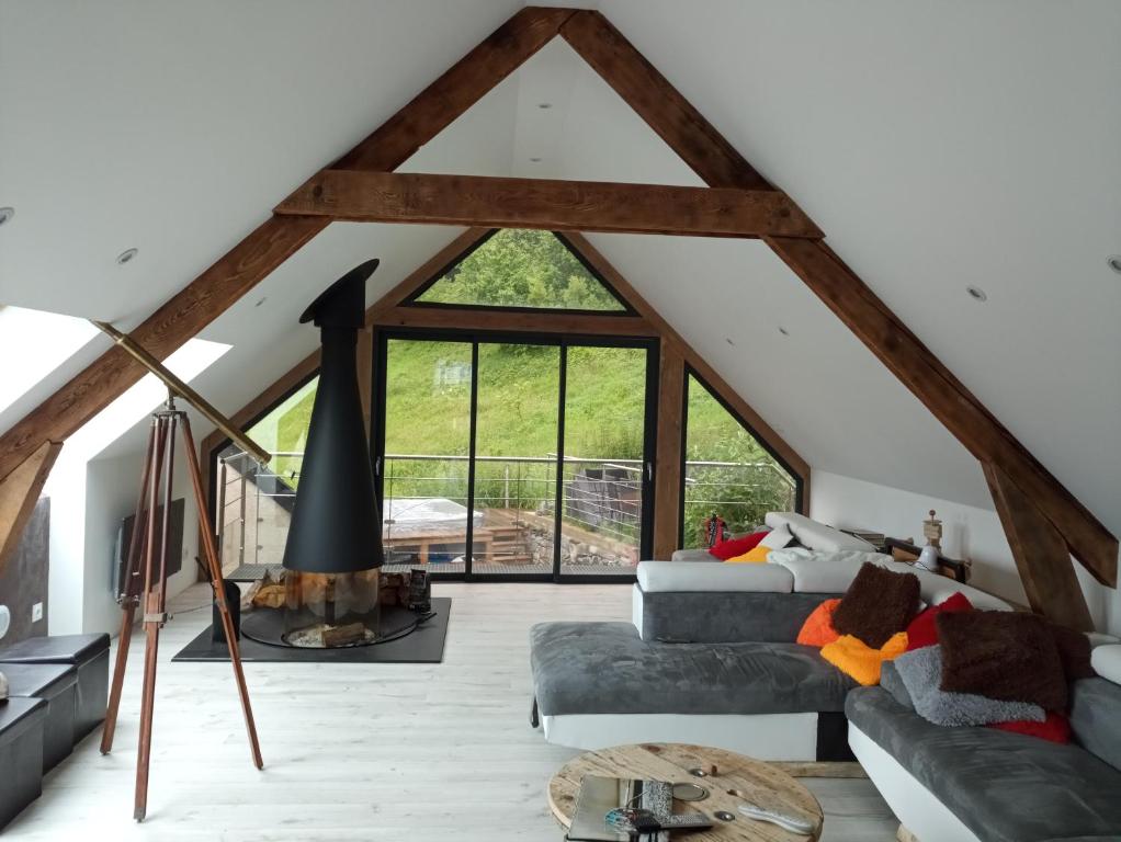 a living room with a loft with a large window at superbe grange rénovée in Grust