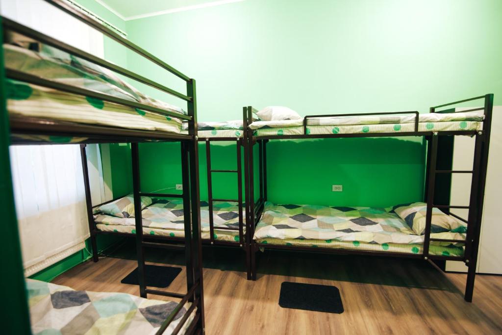 two bunk beds in a room with green walls at Hostel “Lime” in Ivano-Frankivsʼk