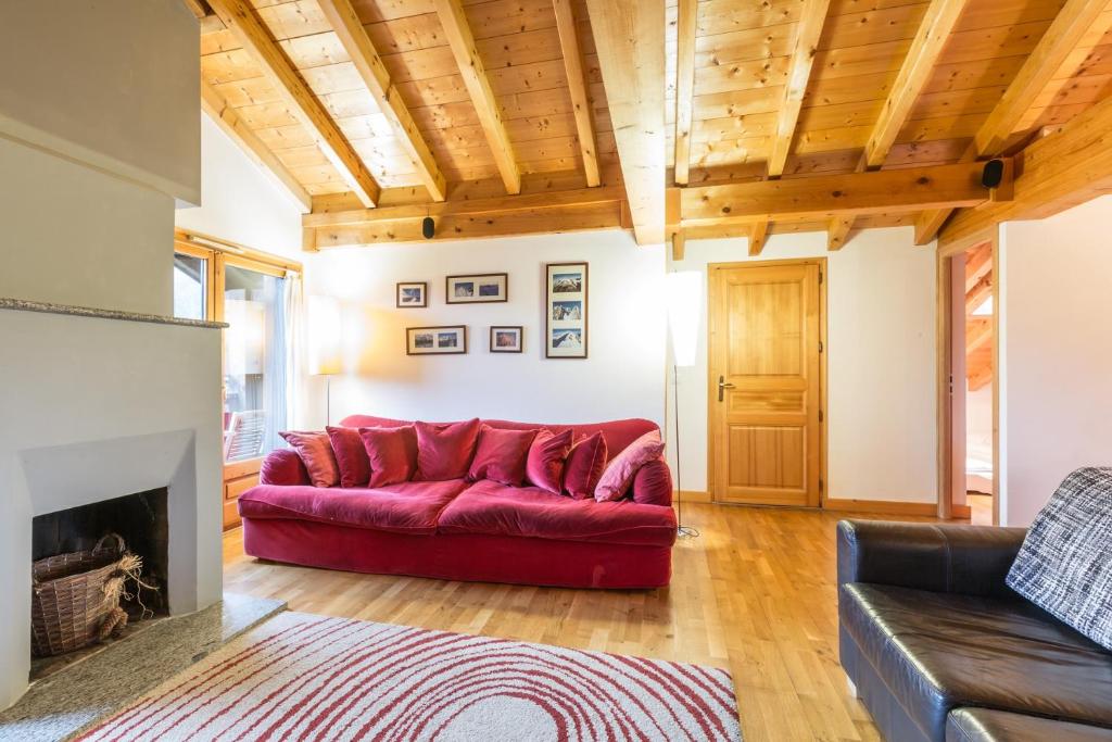 a red couch in a living room with a fireplace at Apartment Capucin in Chamonix