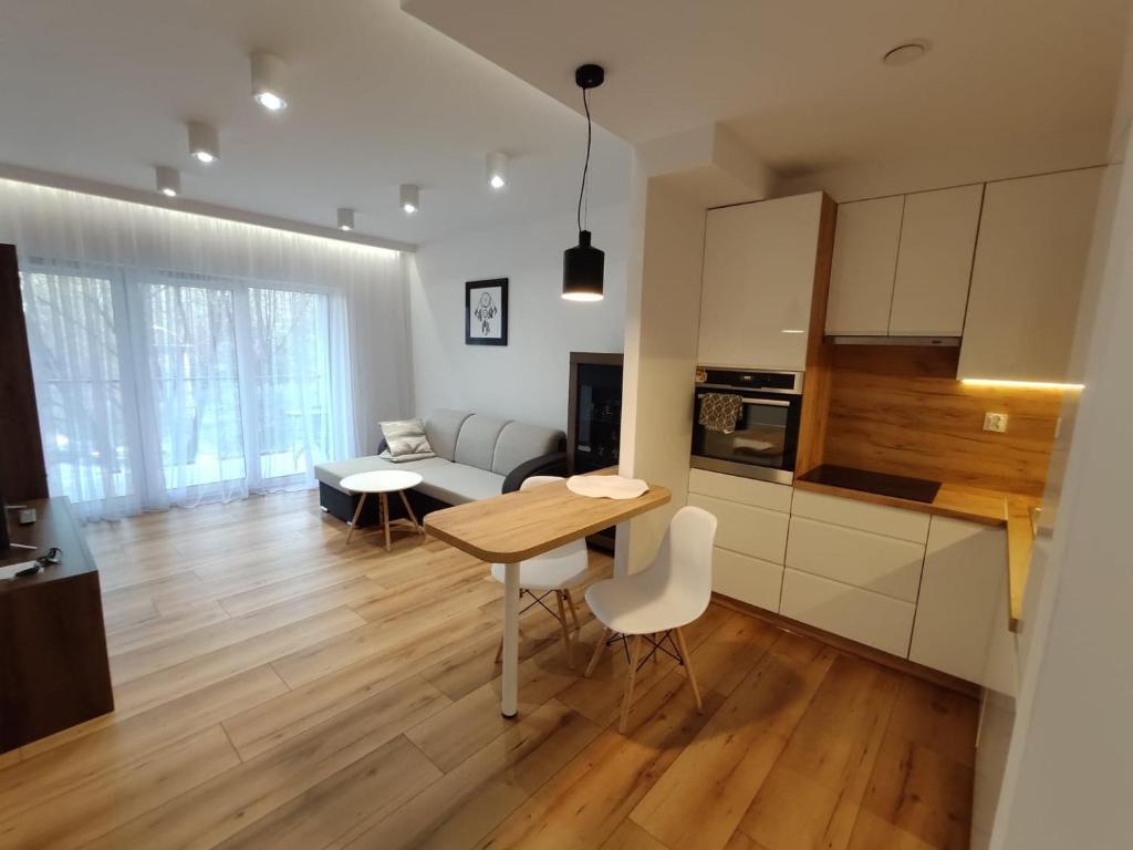 cocina y sala de estar con mesa y sofá en Apartament Parkowy, en Rzeszów