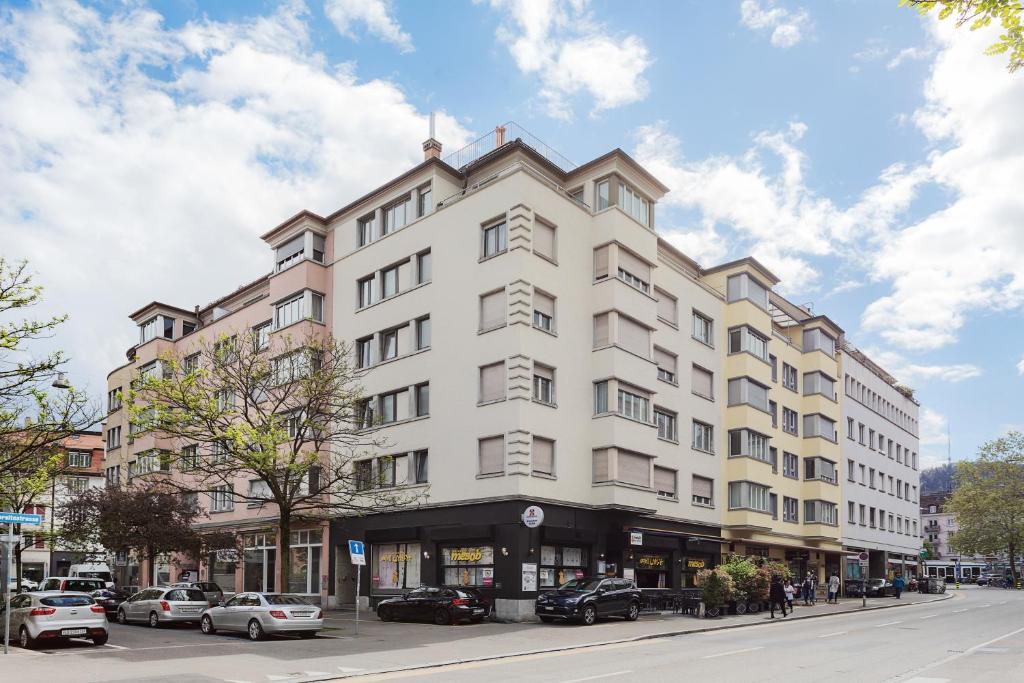 a large white building on a city street at VISIONAPARTMENTS Rotachstrasse - contactless check-in in Zurich