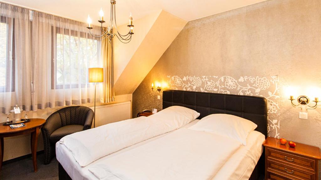 Schlafzimmer mit einem Bett, einem Schreibtisch und einem Fenster in der Unterkunft Art of Comfort Haus Ingeborg in Köln