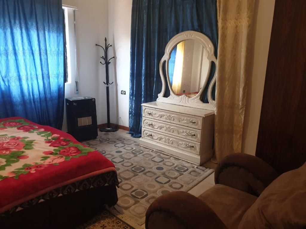 sypialnia z lustrem i komodą z łóżkiem w obiekcie PALM Home w mieście Amman