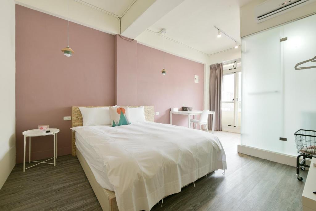 ein Schlafzimmer mit einem großen weißen Bett und einem Tisch in der Unterkunft 逢甲All Night龍 in Taichung