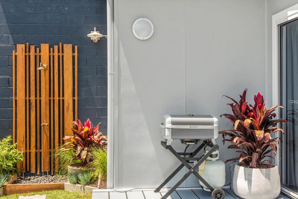 a grill on a stand next to a house with plants at Studio Ocean Breeze @ Huskisson in Huskisson