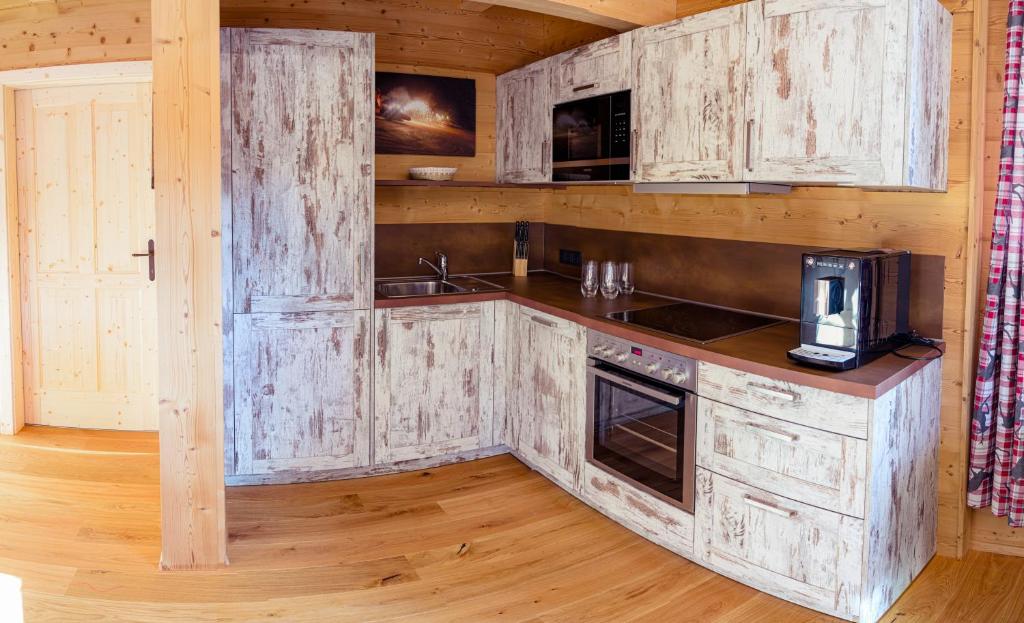 eine Küche mit Holzschränken und einer Arbeitsplatte in der Unterkunft Apartment Fuchsbau in Lachtal