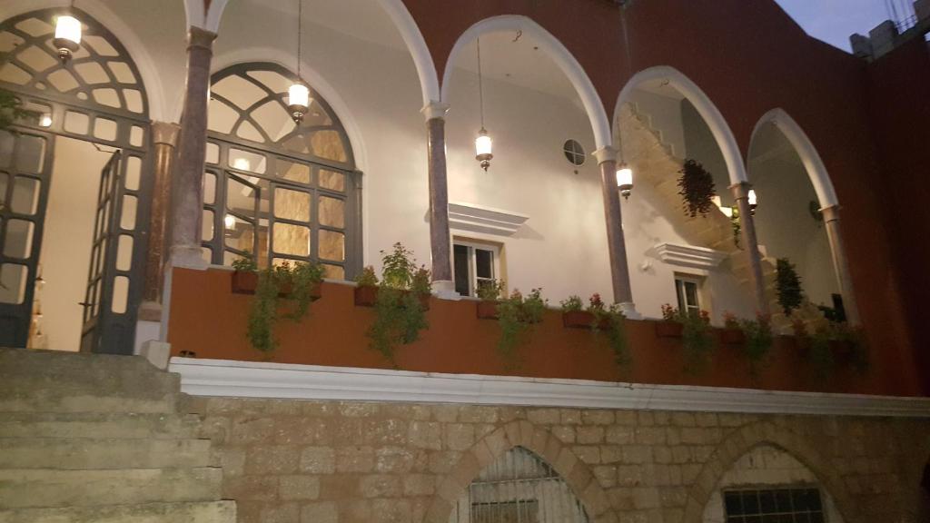 a building with a balcony with potted plants on it at Azur Suites Hotel & Apartments in El Mîna