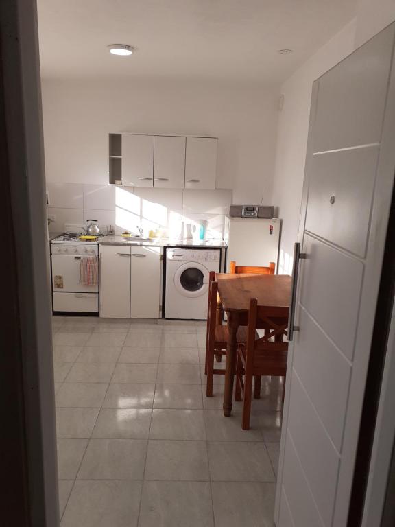 a kitchen with a table and a kitchen with white appliances at Roberta 3 in Bahía Blanca