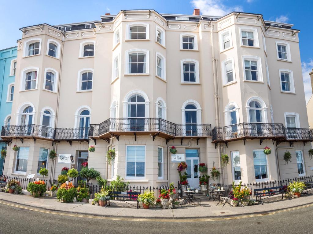 un grande edificio bianco su una strada cittadina di Giltar Hotel a Tenby