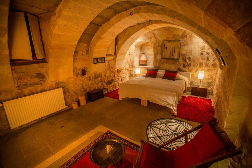 a bedroom with a bed in a stone room at Asmalı Cave House in Uchisar