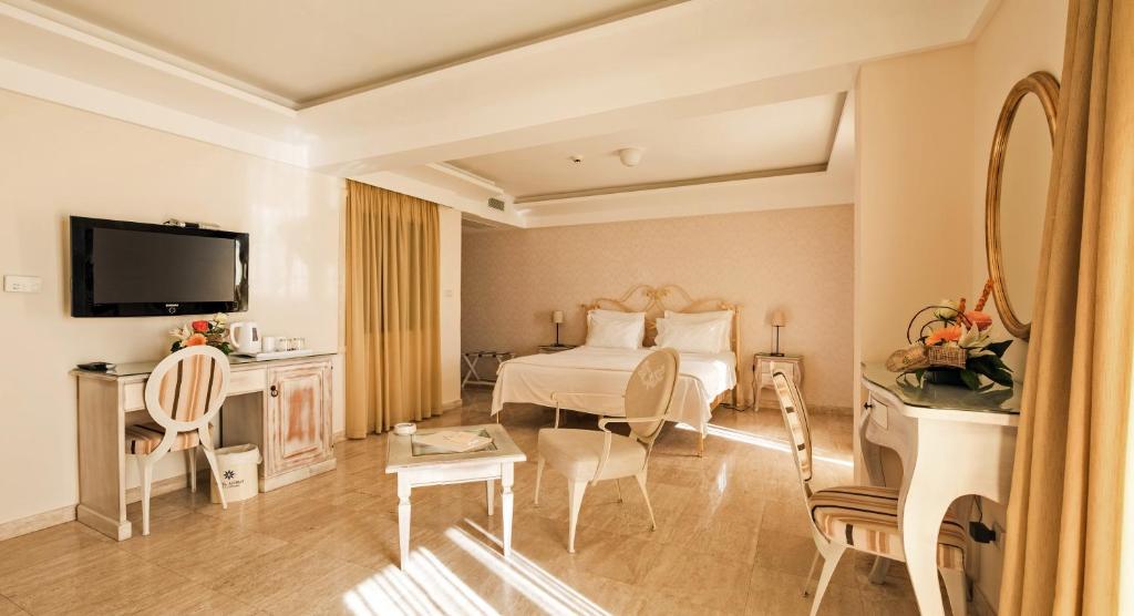 a hotel room with a bed and a television at Hotel Azimut in Sveti Stefan