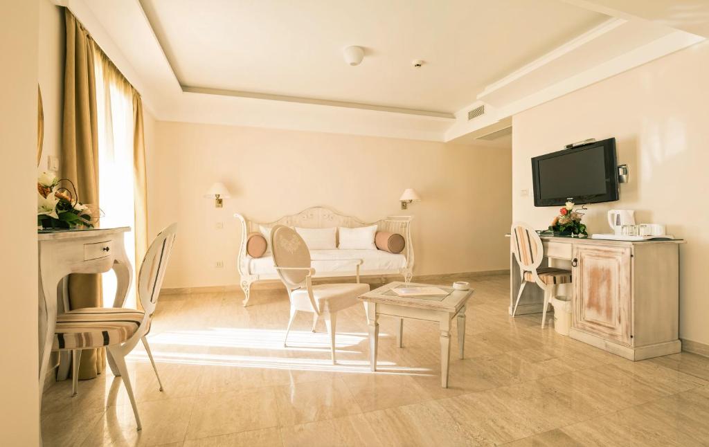 a living room with a couch and chairs and a tv at Hotel Azimut in Sveti Stefan