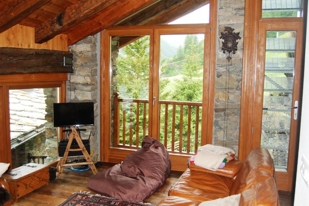 A television and/or entertainment centre at Case Gran Paradiso di Charme Villaggio La Barmaz