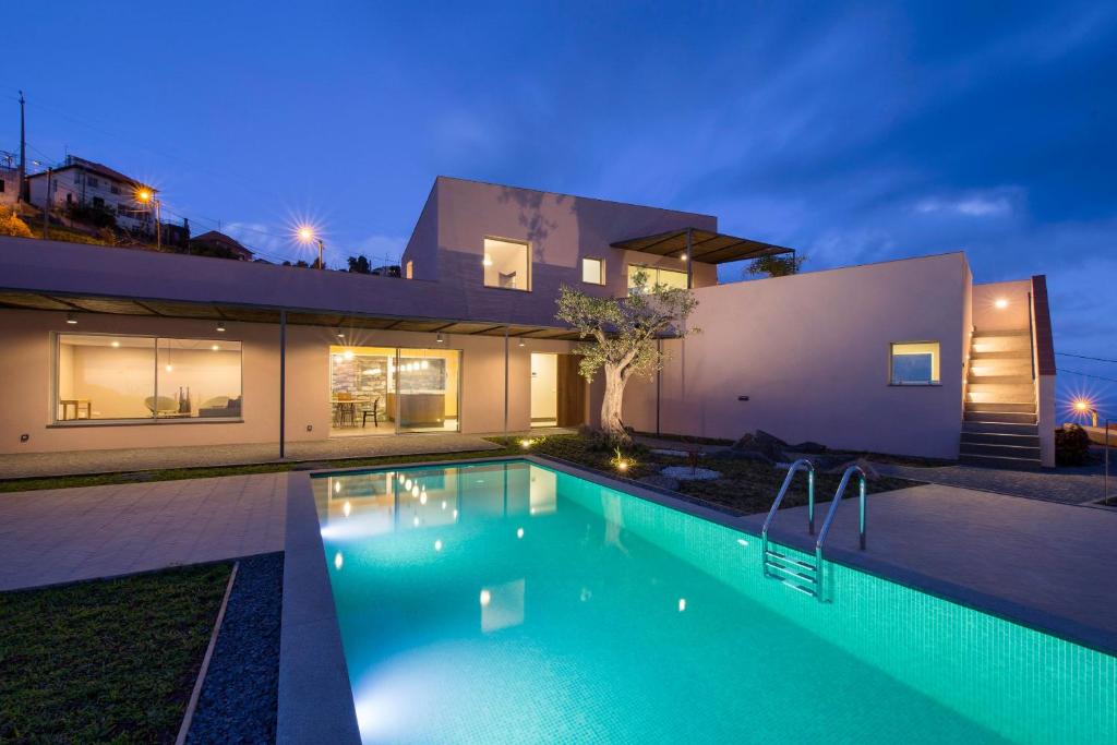 a swimming pool in front of a house at night at Casa Atlantico Dachterrassengeschoss in Ribeira Brava