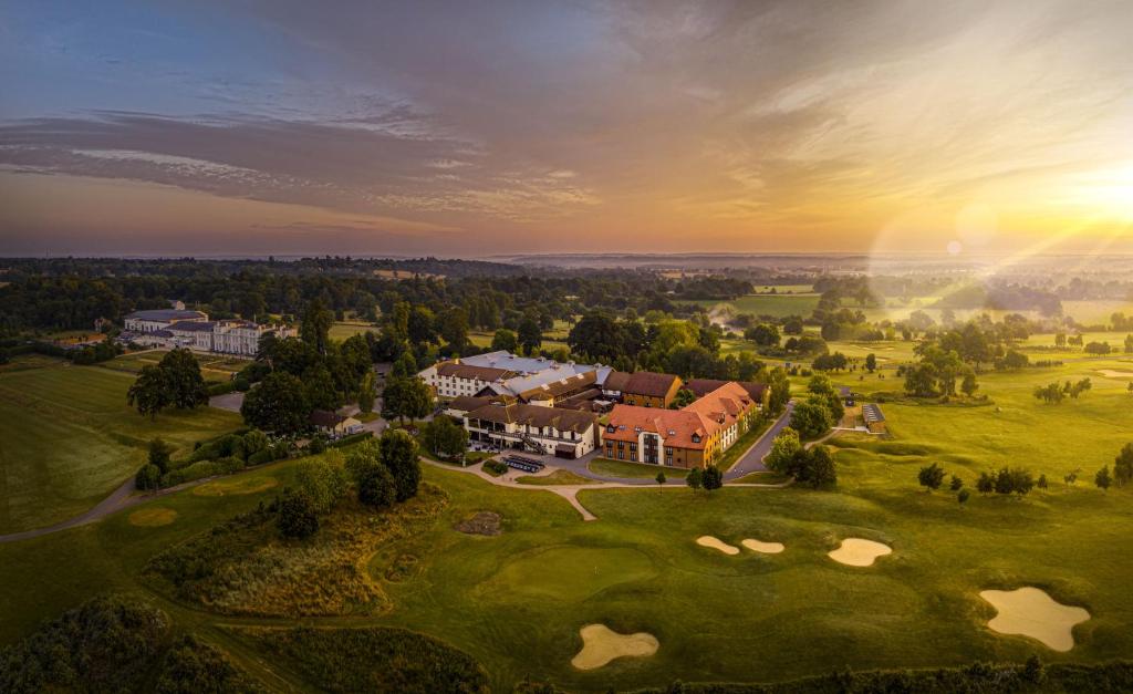 - une vue aérienne sur une maison sur un parcours de golf dans l'établissement De Vere Wokefield Estate, à Reading