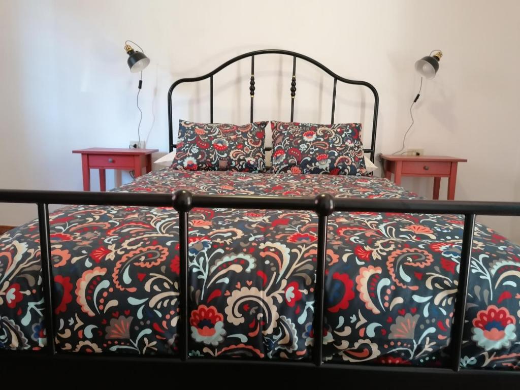 1 cama con colcha negra y roja y 2 mesas en Casa Vista Bella, en El Cercado