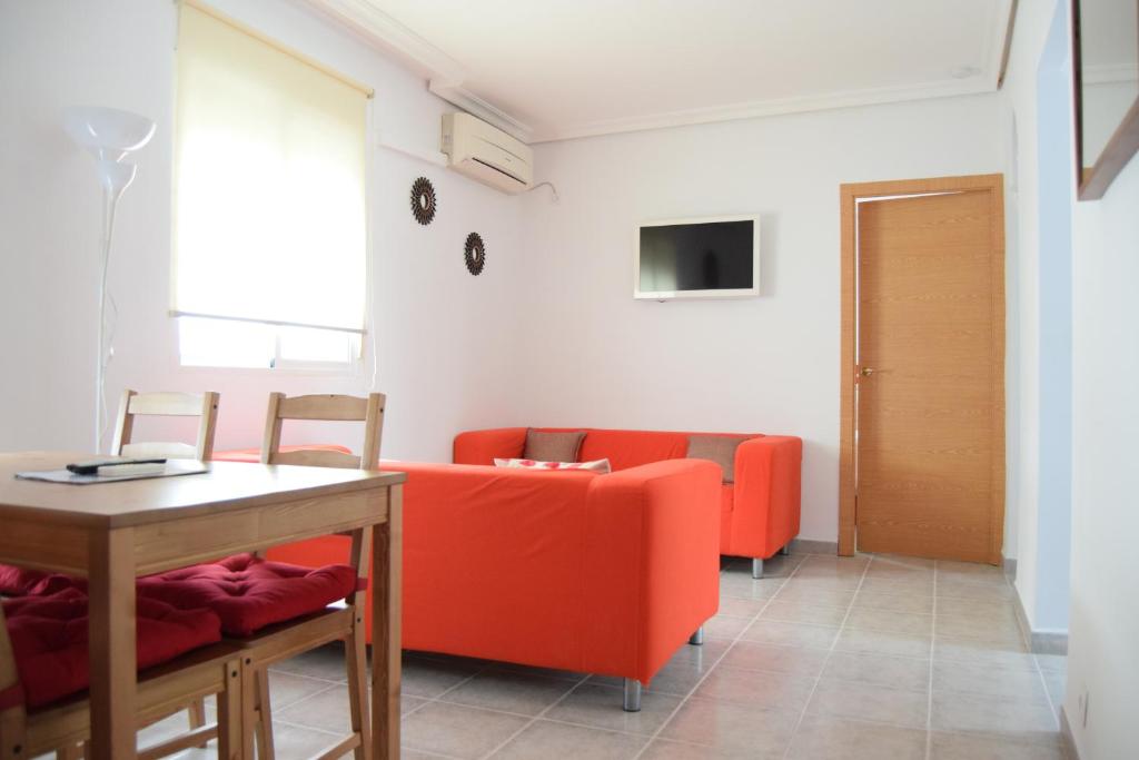 セビリアにあるEnjoy Sevillaのリビングルーム(赤いソファ、テーブル付)