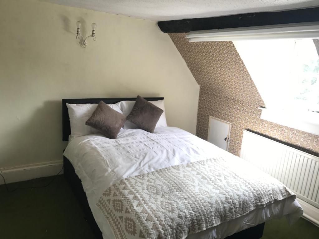 una camera da letto con un letto con lenzuola bianche e una finestra di 1Bedroom Accommodation a Wellesbourne Hastings