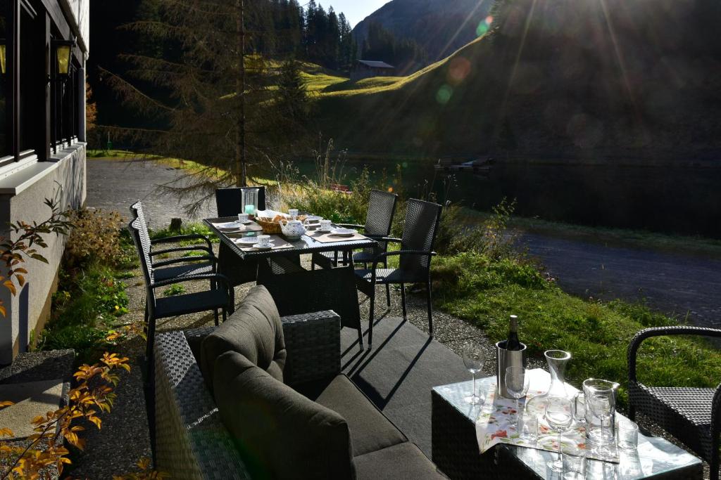 a patio with a table and chairs with a view of a mountain at Appartement Seebachsee in Warth am Arlberg