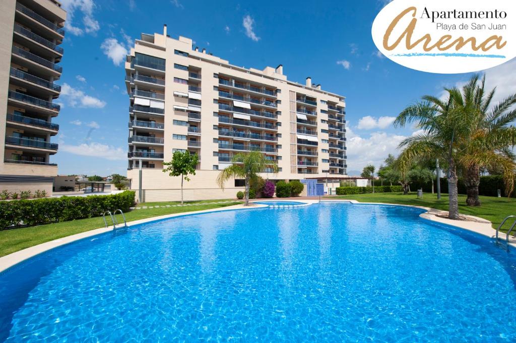 une grande piscine en face d'un bâtiment dans l'établissement APARTAMENTO ARENA en Playa de San Juan, à Alicante