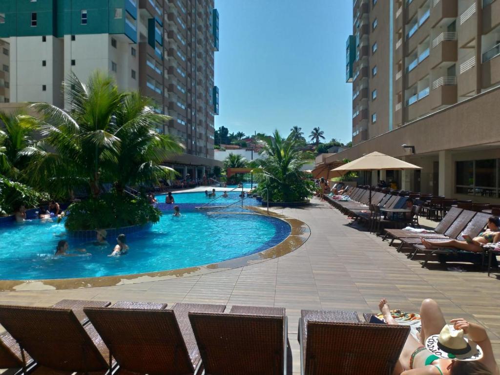 une piscine dans un hôtel avec des gens dedans dans l'établissement Apartamento em Resort de Olimpia, à Olímpia