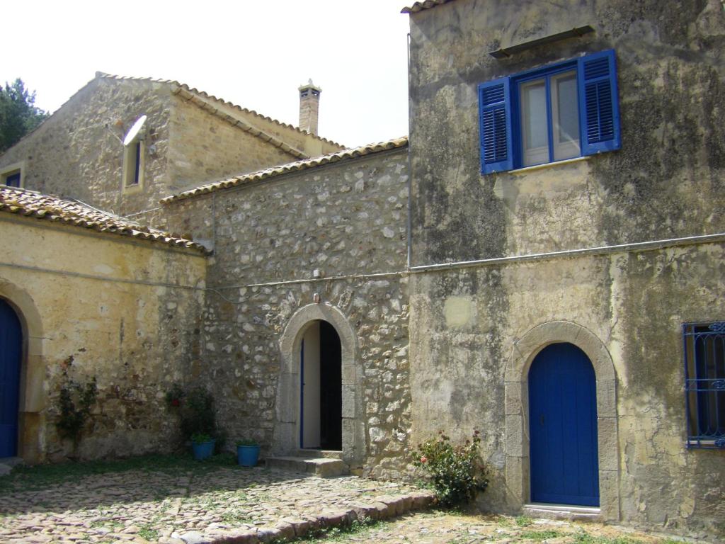 an old stone building with blue doors and windows at Fontanarossa in Cerda