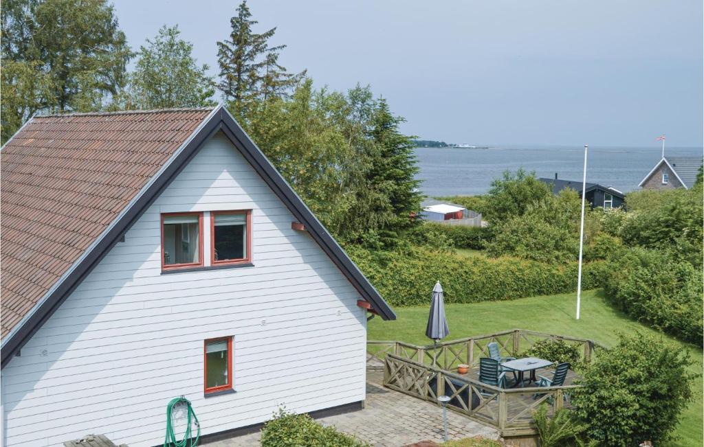 ein weißes Haus mit einem Tisch und einer Terrasse in der Unterkunft Fjordens Perle in Farsø