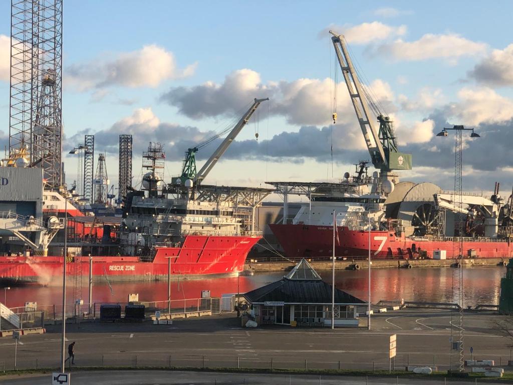 Harbour Living by Jutlandia في فريكشهاون: سفينة حمراء كبيرة في ميناء مع رافعات
