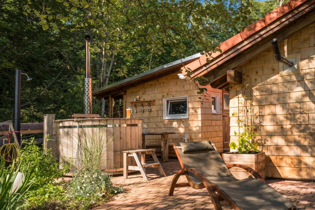 eine Hütte mit 2 Stühlen und einem Tisch auf einer Terrasse in der Unterkunft Jungholz Chalet 65 in Jungholz