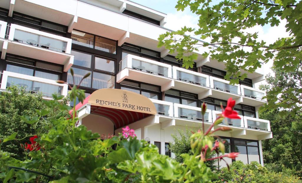 a building with a red flower in front of it at Reichels Parkhotel in Bad Windsheim