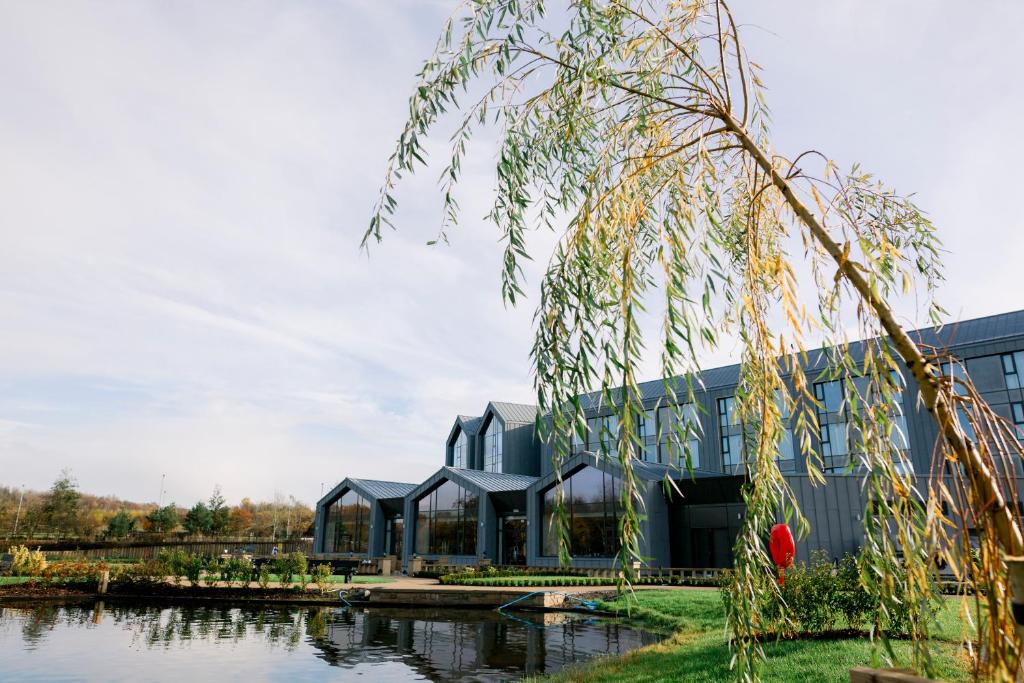 un edificio con un lago frente a él en Crow Wood Hotel & Spa Resort, en Burnley