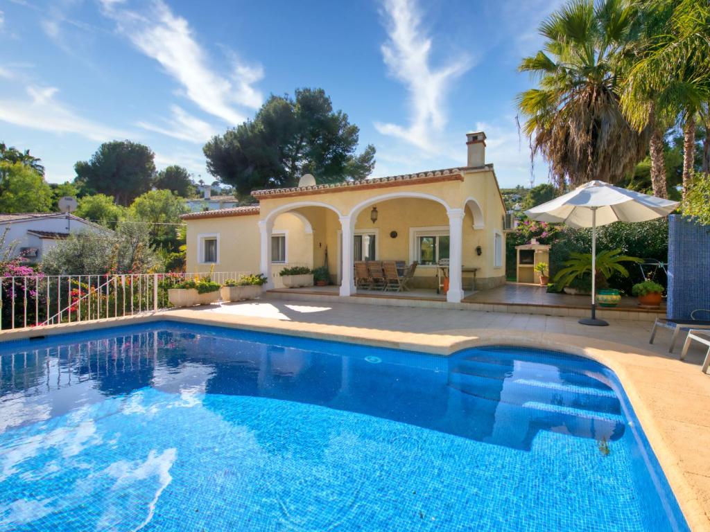 a villa with a swimming pool in front of a house at Villa Eucaliptus by Interhome in Balcon del Mar