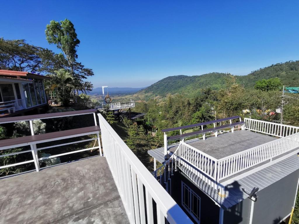a balcony of a house with a view of the mountains at I'm Fine Khaokho resort in Khao Kho